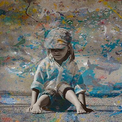 Kind mit Farbspritzern Kind sitzt vor Wand