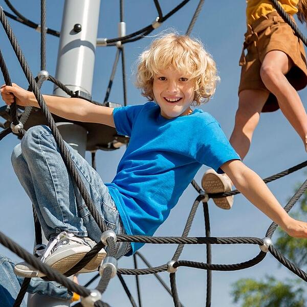 Kind turnt und spielt auf einem Spielplatz