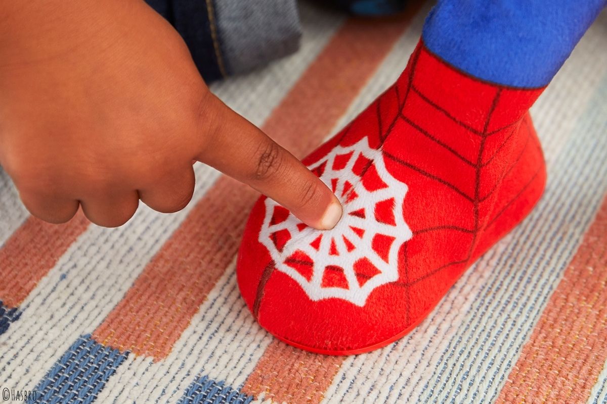 Kinderfinger zeigt auf Spidey-Spielzeug-Fuß