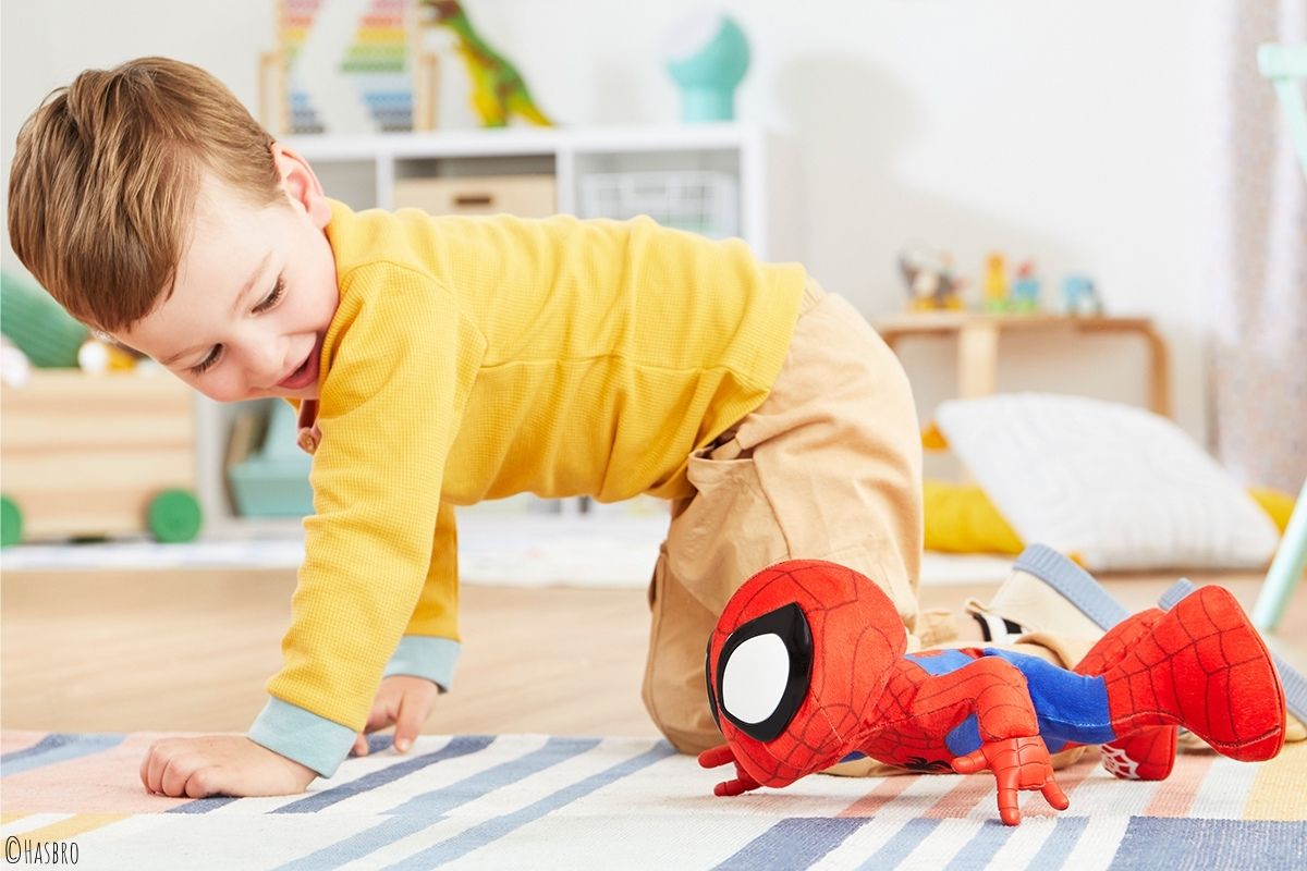 Kind krabbelt zusammen mit Spidey-Spielzeug