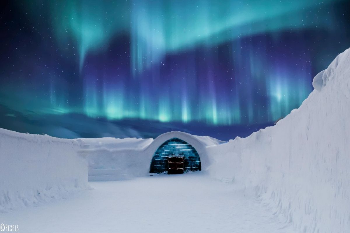 Höhle in einer Schneelandschaft unter den Polarlichtern