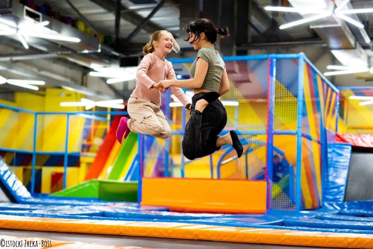 Mutter und Tochter springen gemeinsam in einer Trampolinhalle