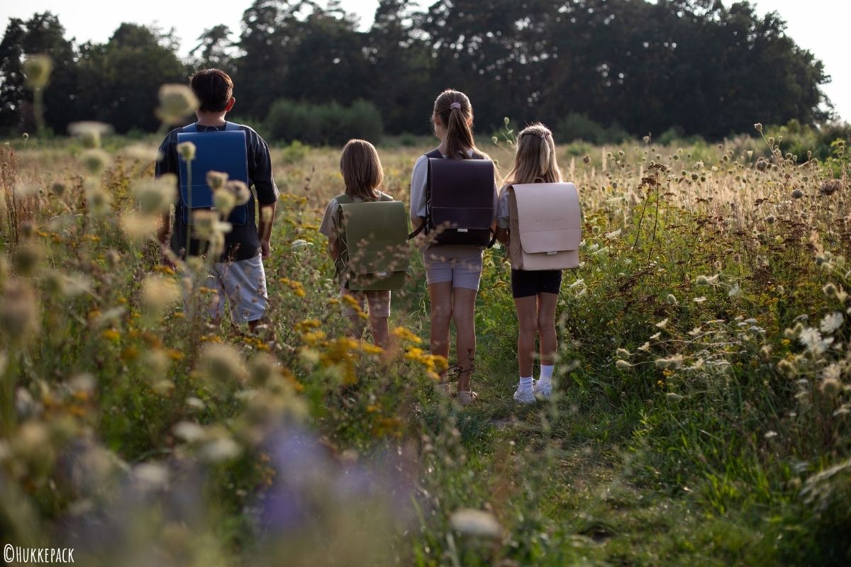 Familie in Feld/Wiese mit Rucksäcken