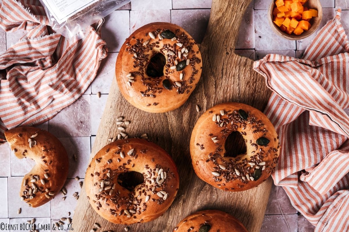 3 Kürbis Bagel serviert auf Holzbrett